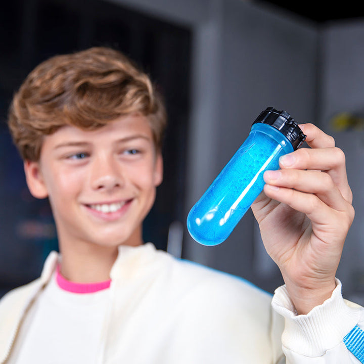 Happy child holding a blue test tube filled with liquid, excited to create MrBeast Lab Swarms experiments.