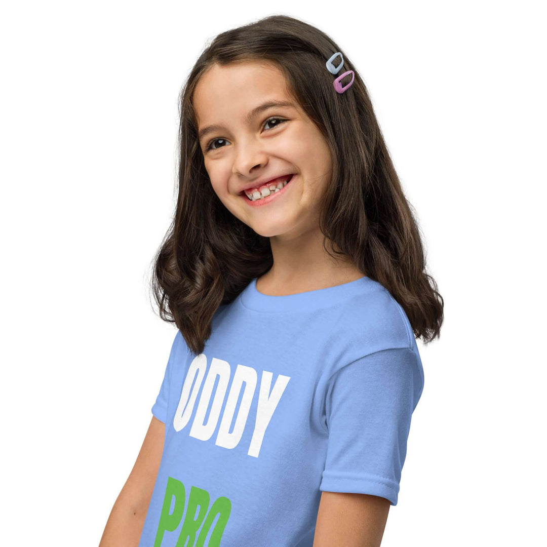 Smiling girl wearing a blue Oddy Pro Youth t-shirt, showcasing comfort and style for kids.