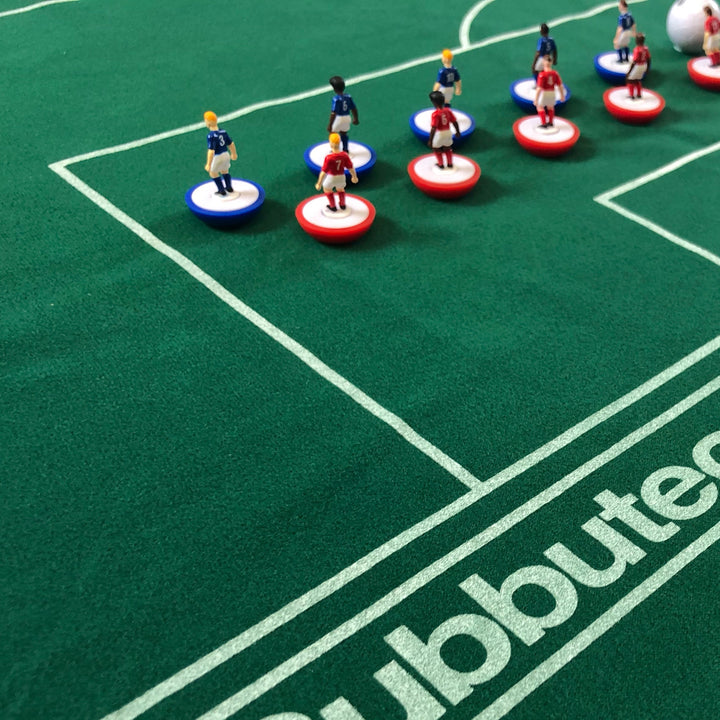 Subbuteo Main Game with colorful player figurines on a detailed football pitch.